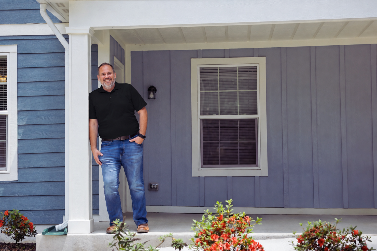Jeff Bennett standing on the porch of a blue home